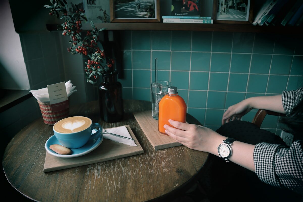 Hands holding a takeaway coffee cup in a cafe