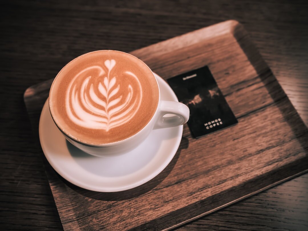 A cappuccino on a wooden tray with a card