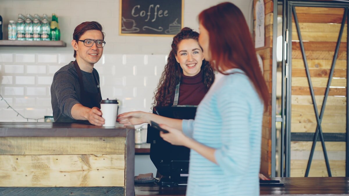Hands holding a takeaway coffee cup in a cafe